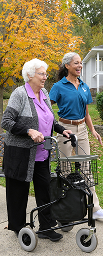 An elderly woman practicing balance exercises with the guidance of a Visiting Angels caregiver, focusing on fall prevention and mobility support.