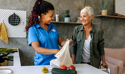 A Visiting Angels caregiver providing respite care for an elderly woman, allowing family members to take a break while ensuring comfort and safety.