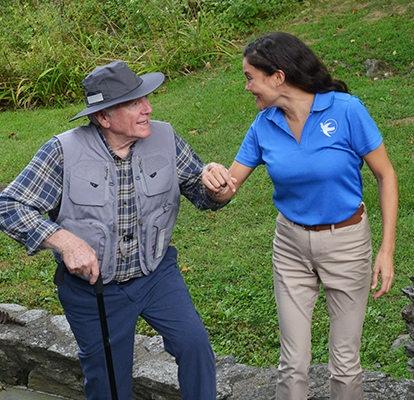 A Visiting Angels caregiver assisting an elderly woman with mobility, demonstrating fall prevention strategies in a safe home environment.